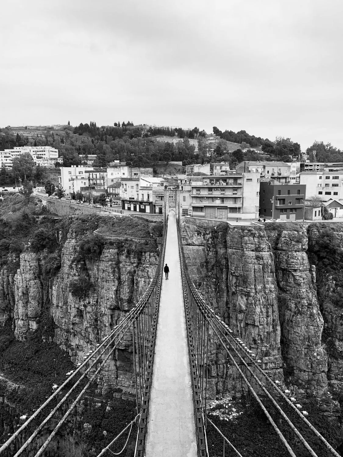 Narrow footbridge over the gorge in black and white